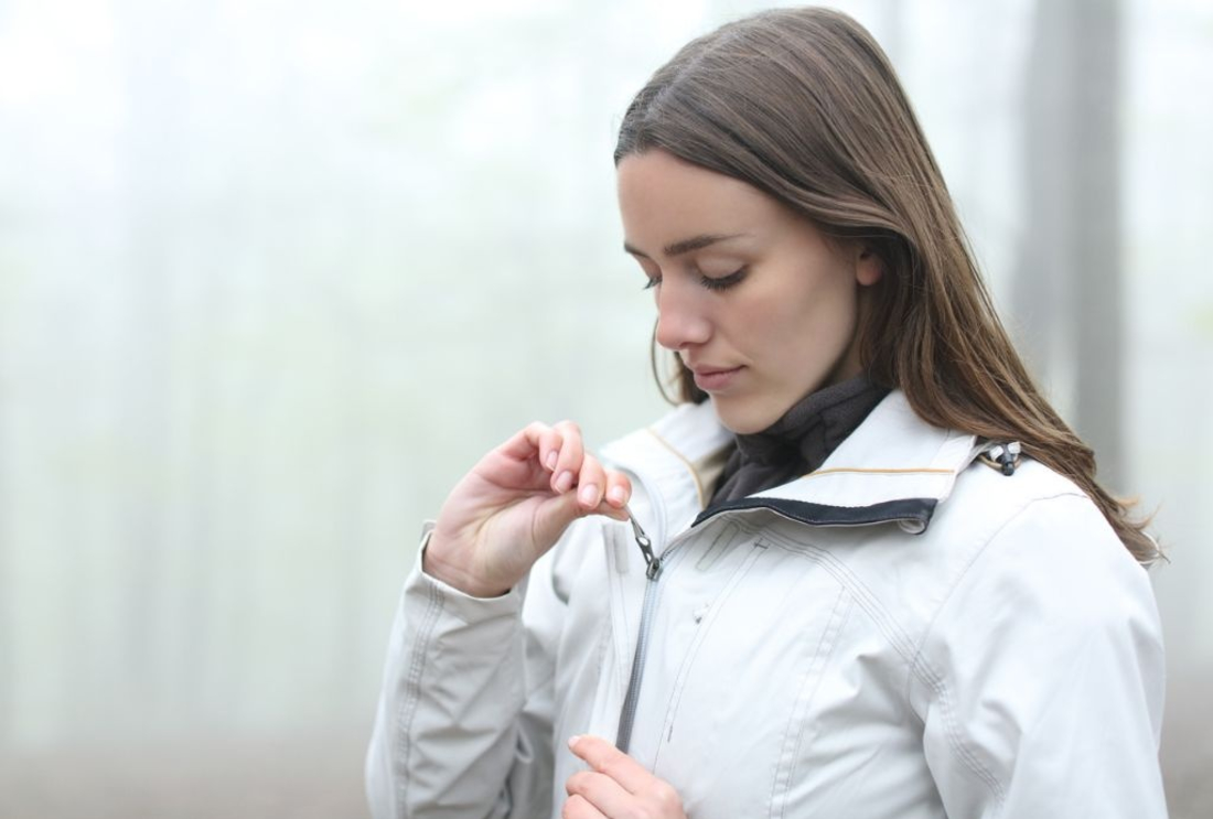 Image of a person zipping up a jacket