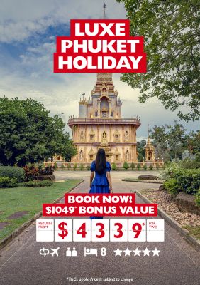 Luxe Phuket holiday | book now! $1,049 bonus value | return from $4,339* for two. Woman in a blue dress walking towards a tall temple in Phuket