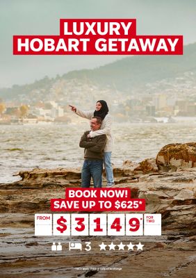 Luxury Hobart getaway | book now! Save up to $625* - from $3,149* for two. Couple hugging, standing on rocks looking out to sea