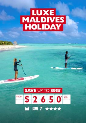 Luxe Maldives holiday | save up to $955* from $2,650* for two. Couple stand-up paddle boarding