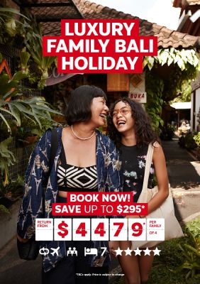 Luxury Family Bali Holiday | Book Now! Save up to $295*. Return from $4,479* per family of 4. Two women laughing, walking through a street lined with tropical plants