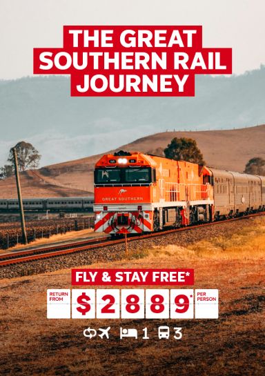 The Great Southern Rail journey | fly & stay free*. Return from $2,889* per person. Orange train steaming through the Australian outback