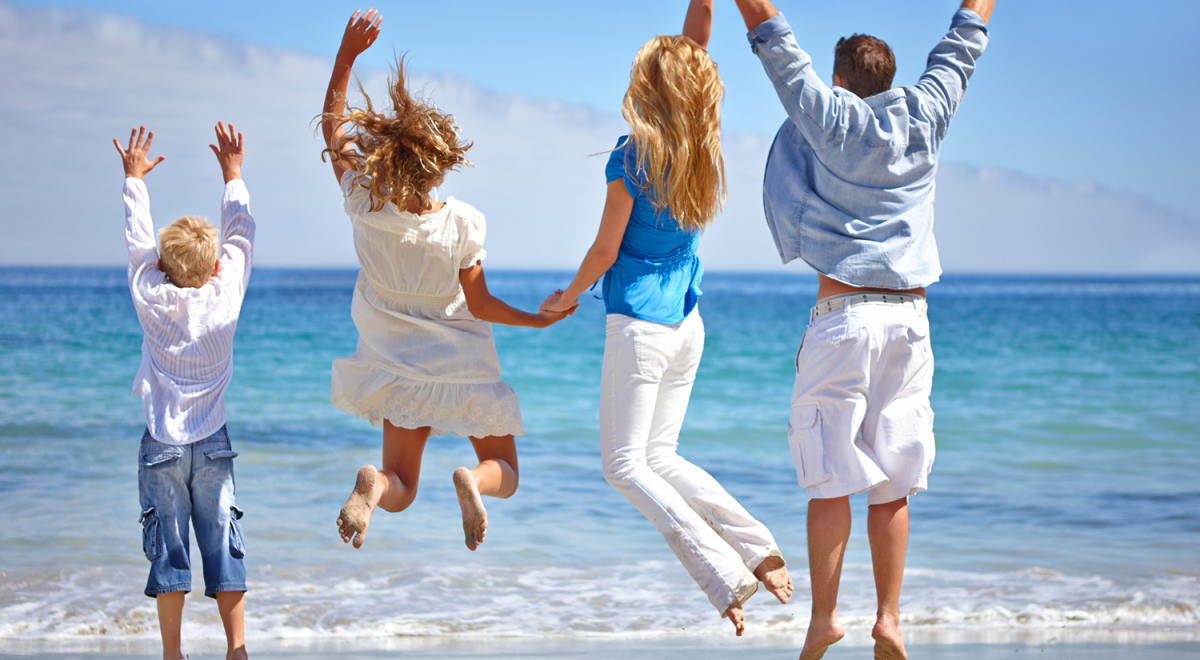 Family jumping for joy on the beach on vacation