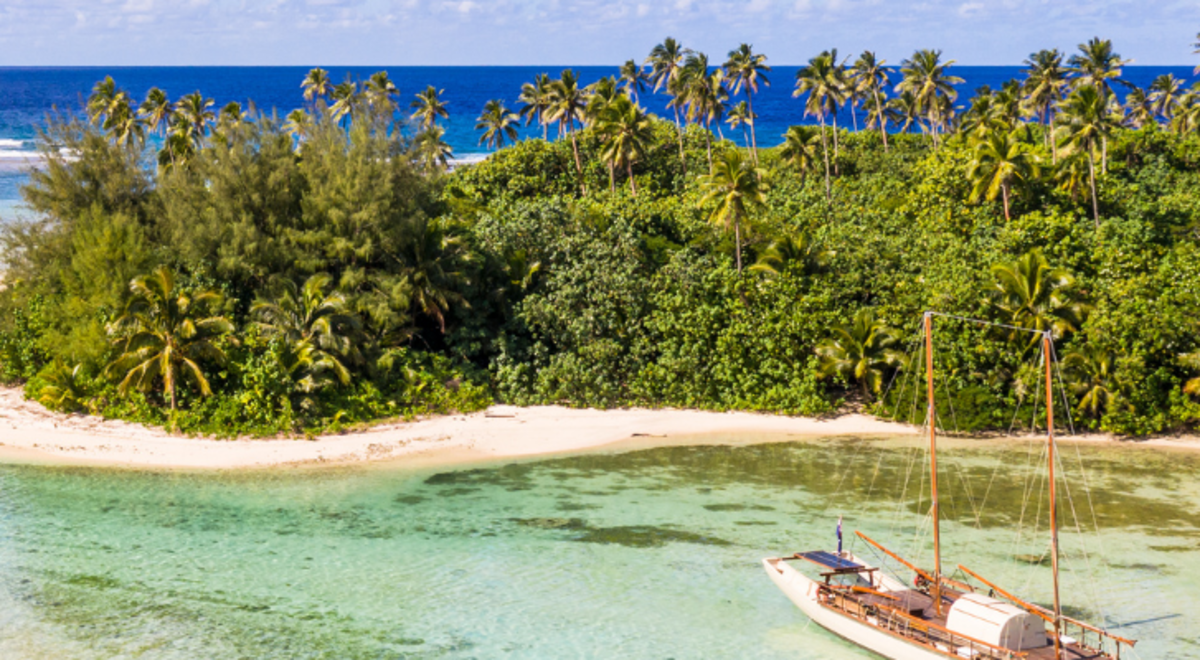 Sailboat approaching the shore of an island