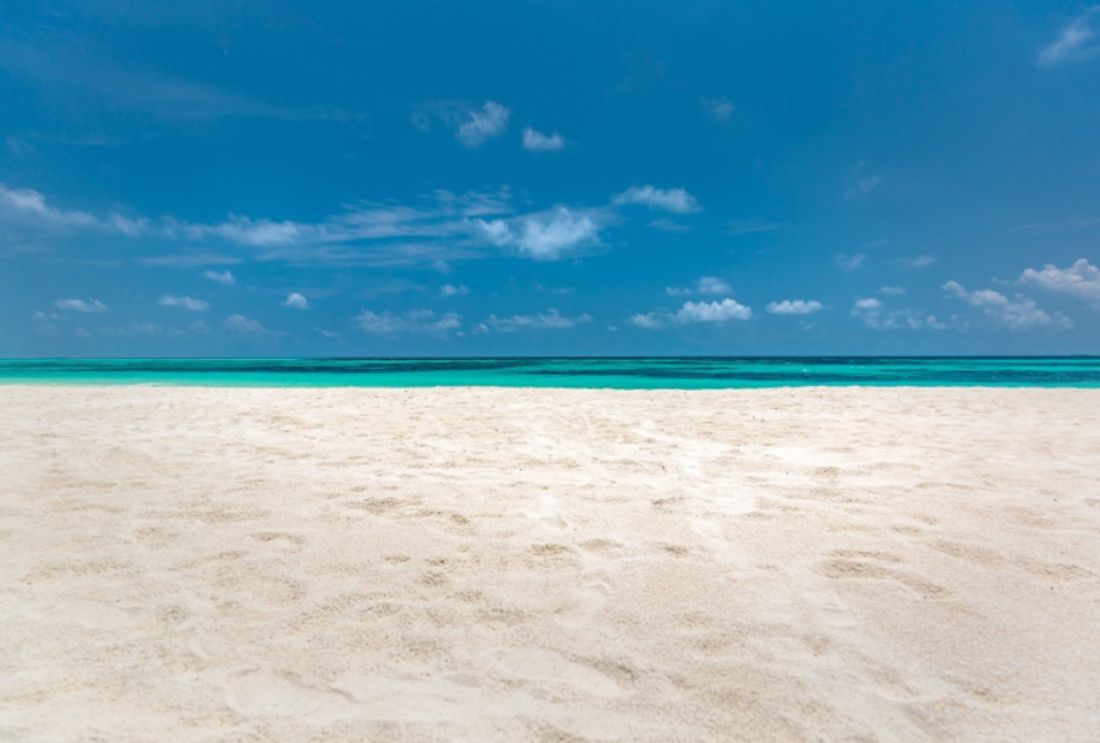 An empty white-sandy beach and blue sky