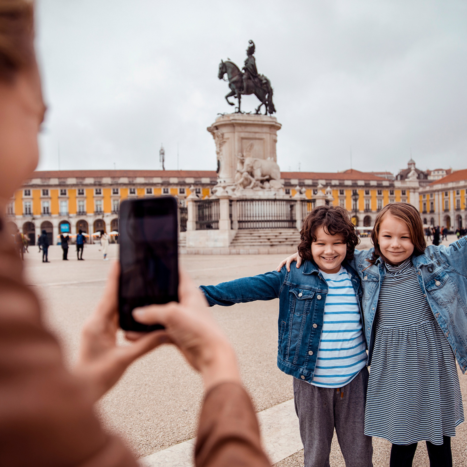 Family on vacation in Lisbon taking a photo at Monument to King José