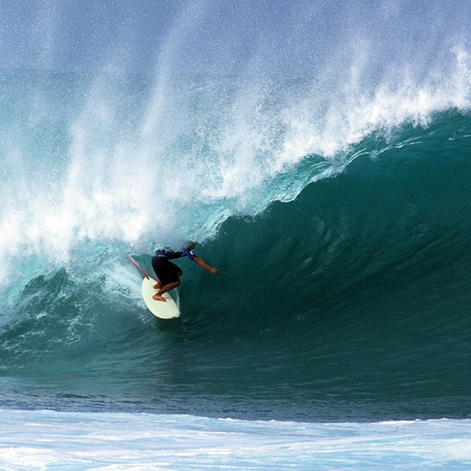 Surfer riding a large, crashing wave