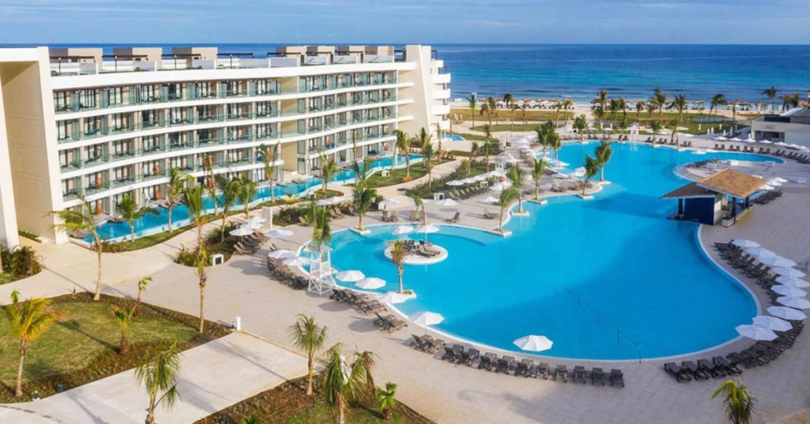Ocean Coral Spring Resort in Jamaica - large white hotel an immense bright blue pool in front