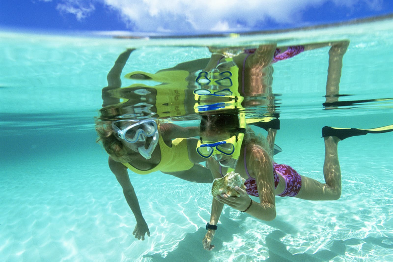A mother and daughter snorkelling in shallow water
