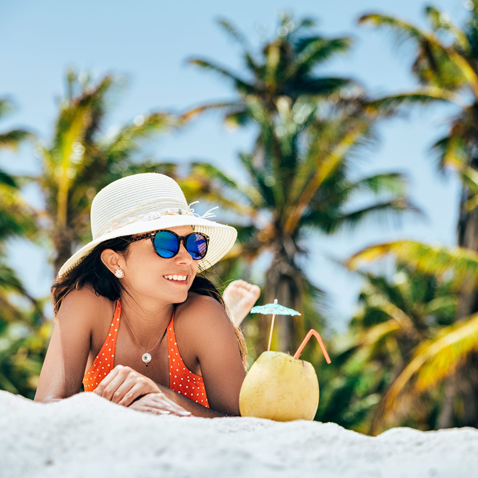 Woman enjoying a coconut beverage on the beach