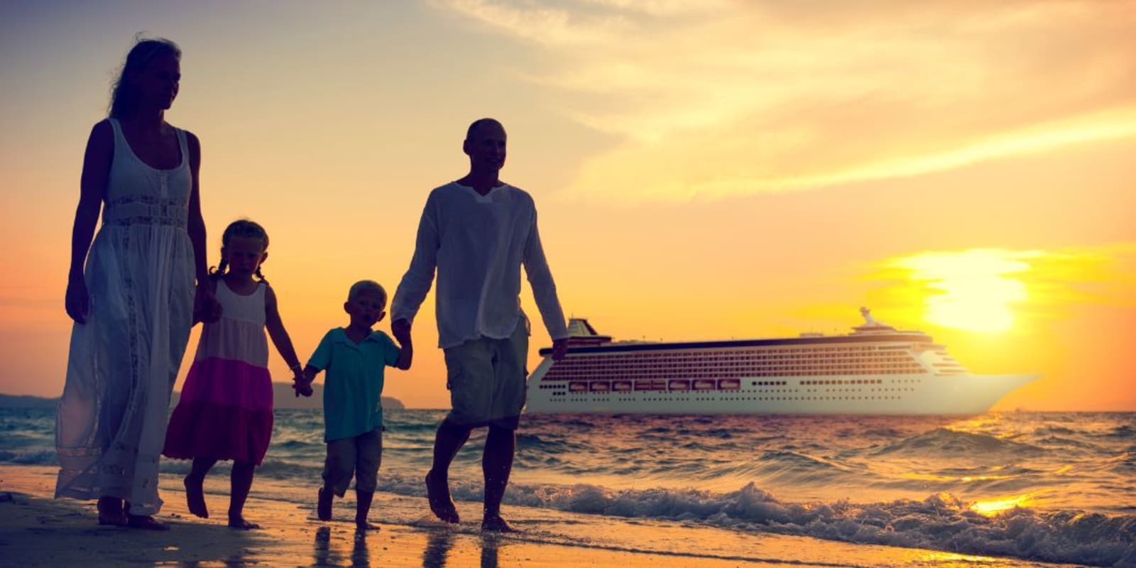 A family walking along a beach at sunset with a cruise ship in the background