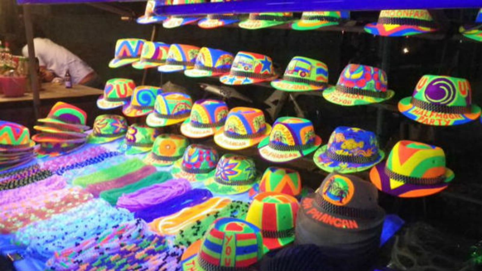Multi-coloured hats and beaded necklaces on sale at a market stall