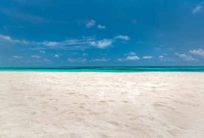 An empty white-sandy beach and blue sky