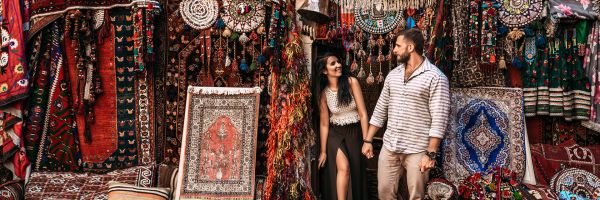 Couple smiling while browsing a carpet bazar in Istanbul
