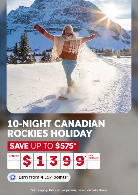 Person joyfully kicking snow in the Canadian Rockies with snow-capped peaks behind for a 10-night holiday saving up to $575 from $1399 per person