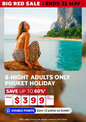 Woman smiling on rocks beside turquoise Phuket waters and limestone cliffs for a Big Red Sale 8-night adults only holiday saving up to 60% from $399