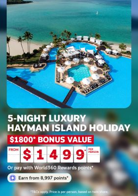 Aerial view of an ornate resort pool beside turquoise Hayman Island lagoon for a 5-night luxury holiday with $1800 bonus value from $1499 per person