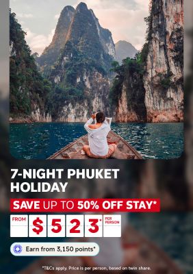 Person on a wooden longtail boat gazing at towering jungle karst cliffs for a 7-night Phuket holiday saving up to 50% off stay from $523 per person