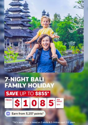 A travel promotional banner featuring a smiling man in a blue t-shirt carrying a young child on his shoulders in front of a traditional Balinese temple. The child, wearing a yellow shirt, smiles and spreads their arms wide. Text below reads: "7-Night Bali Family Holiday – Save up to $855* – From $1,085* per family of 4. Earn from 3,237 points*." Fine print states: "T&Cs apply. Price is based on 2 adults & 2 children aged 2–11 years."