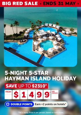 Hayman Island resort pool beside a turquoise beach for a Big Red Sale 5-night 5-star holiday saving up to $2310 from $1499 per person