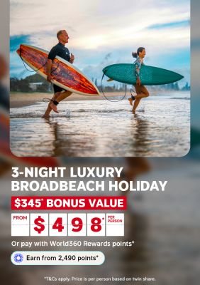Couple running along the shoreline carrying surfboards for a 3-night luxury Broadbeach holiday with $345 bonus value from $498 per person