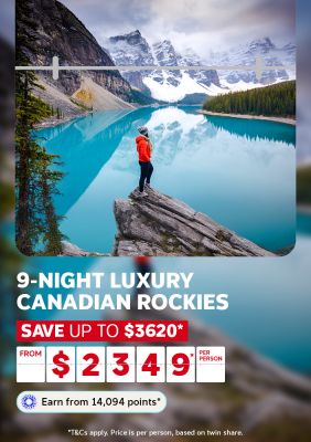 Woman standing on a rock overlooking a turquoise lake in the snow capped Canadian Rockies for a 9-night trip saving up to $3620 from $2349 per person