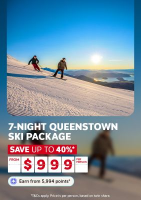 Two skiers on a sun-drenched Queenstown slope with a lake panorama below for a 7-night Queenstown ski package saving up to 40% from $999 per person