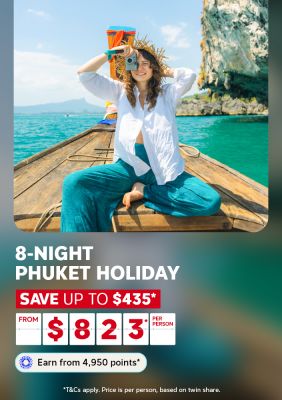 Woman photographing from a longtail boat on turquoise water beside limestone cliffs for an 8-night Phuket holiday saving $435 from $823 per person