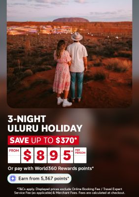 Couple watching Uluru glow at sunset over illuminated desert lights for a 3-night Uluru holiday saving up to 370 from 895 per person