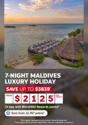 Golden sunset over turquoise Maldives lagoon with beachfront dining pavilion and thatched bungalow for a 7-night luxury holiday from $2125