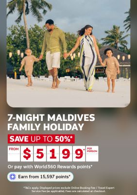 Parents holding hands with two young boys walking along a white sand beach at dusk for a 7 night Maldives family holiday from $5199 per person saving up to 50%