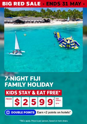 Catamaran on turquoise Fijian waters beside an inflatable water park for a 7-night family holiday with kids stay and eat free from $2599 per family of 4