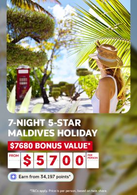 Woman in a straw hat on a palm-fringed Maldives island path for a 7-night 5-star Maldives holiday with $7680 bonus value from $5700 per person