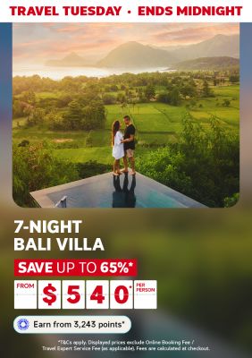 Couple standing on the edge of a reflective platform overlooking lush, green fields featuring a 7-night Bali villa from $540