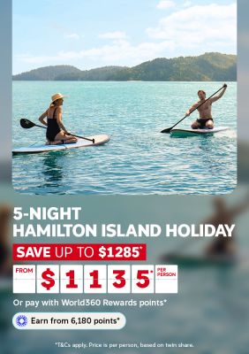 Two people paddleboarding on turquoise water framed by green hills for a 5-night Hamilton Island holiday saving up to $1285 from $1135 per person