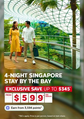 Couple strolling through the lush greenhouse dome at Jewel Changi Airport for a 4-night Singapore stay by the bay saving up to $345 from $599 per person