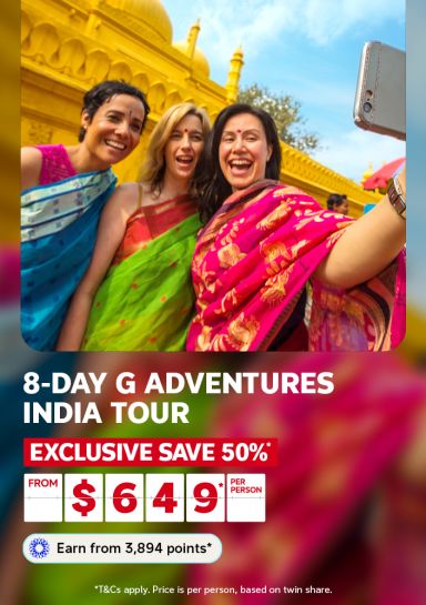 Three women in vibrant saris laughing and taking a selfie at a golden Indian temple for an 8-day G Adventures India tour saving 50% from $649 per person