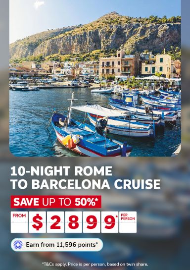 Colorful fishing boats moored in a Sicilian harbour beneath rocky cliffs for a 10-night Rome to Barcelona cruise from $2899 per person