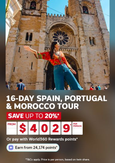 Woman with arms outstretched before a grand Lisbon cathedral for a 16-day Spain Portugal and Morocco tour saving up to 20% from $4029 per person