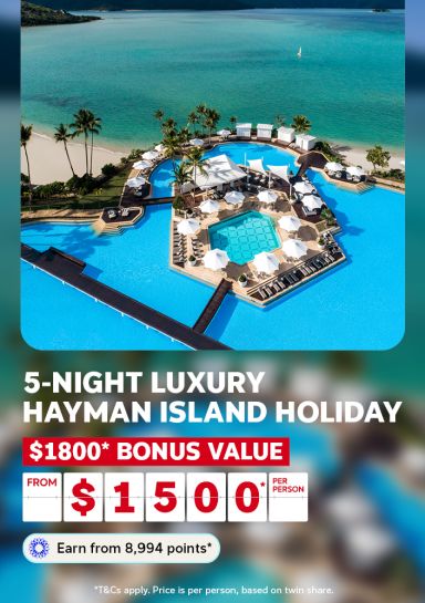 Aerial view of a luxury lagoon pool and beach for a 5-night Hayman Island holiday with $1800 bonus value from $1500 per person