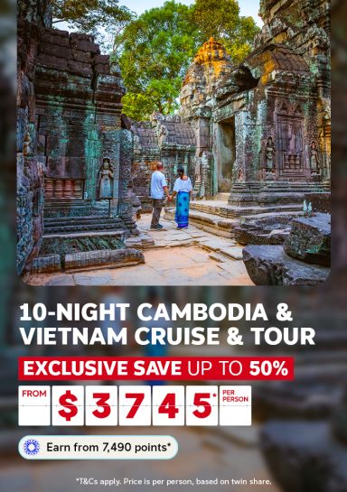 Couple walking through ancient Angkor Wat temple ruins for a 10-night Cambodia and Vietnam cruise and tour saving up to 50% from $3745 per person