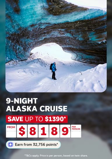 Hiker beneath a glowing blue glacial ice cave arch in Alaska for a 9-night cruise saving up to $1390 from $8189 per person