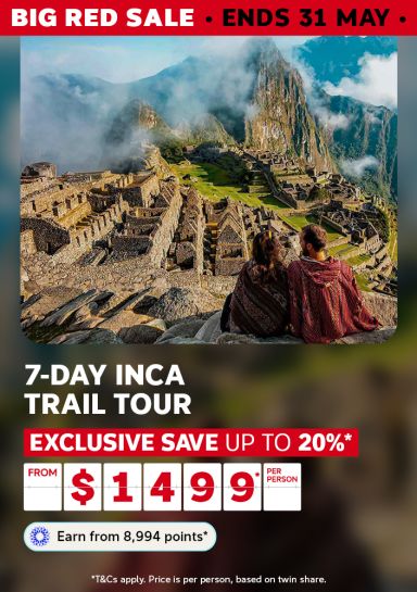 Two travellers in ponchos gazing over misty Machu Picchu ruins for a Big Red Sale 7-day Inca Trail tour saving up to 20% from $1499 per person