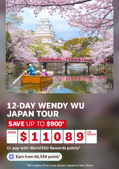 Wooden boat drifting beneath cherry blossoms near a Japanese castle for a 12-day Wendy Wu Japan tour saving up to $900 from $1089 per person
