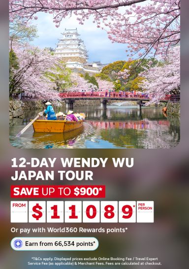 Boatman rowing beneath a cherry blossom bridge near a white castle for a 12 day Wendy Wu Japan tour saving up to 900 dollars from 11089 per person