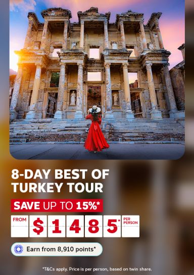 Woman in a flowing red dress admiring the ancient Library of Celsus at Ephesus for an 8-day best of Turkey tour from $1485 per person