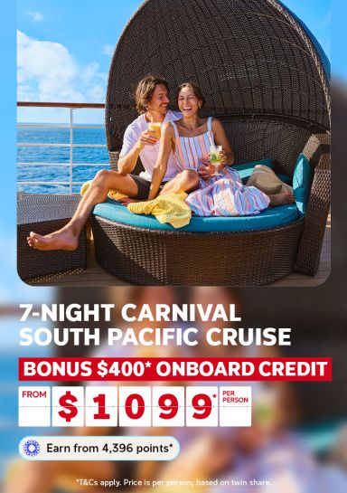 A travel promotional banner featuring a couple relaxing on a wicker daybed with teal cushions on a cruise ship deck, with the ocean and blue sky visible behind them. The man holds an orange drink and the woman holds a cocktail with mint, both smiling and laughing. Text reads: "7-Night Carnival South Pacific Cruise – Bonus $400* Onboard Credit – From $1,099* per person. Earn from 4,396 points*." Fine print states: "T&Cs apply. Price is per person, based on twin share."