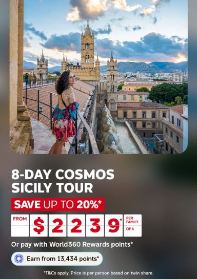 Woman in a floral dress admiring Palermo Cathedral from a rooftop for an 8-day Cosmos Sicily tour saving up to 20% from $2239 per family of 4