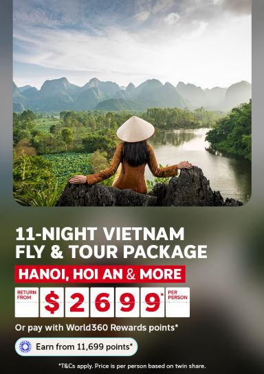 Woman in a conical hat overlooking misty mountains and a river for an 11-night Vietnam tour package to Hanoi Hoi An and more from $2699 per person