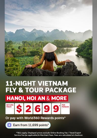 Woman in a conical hat overlooking a river through limestone mountains for an 11 night Vietnam tour visiting Hanoi and Hoi An from 2699 per person